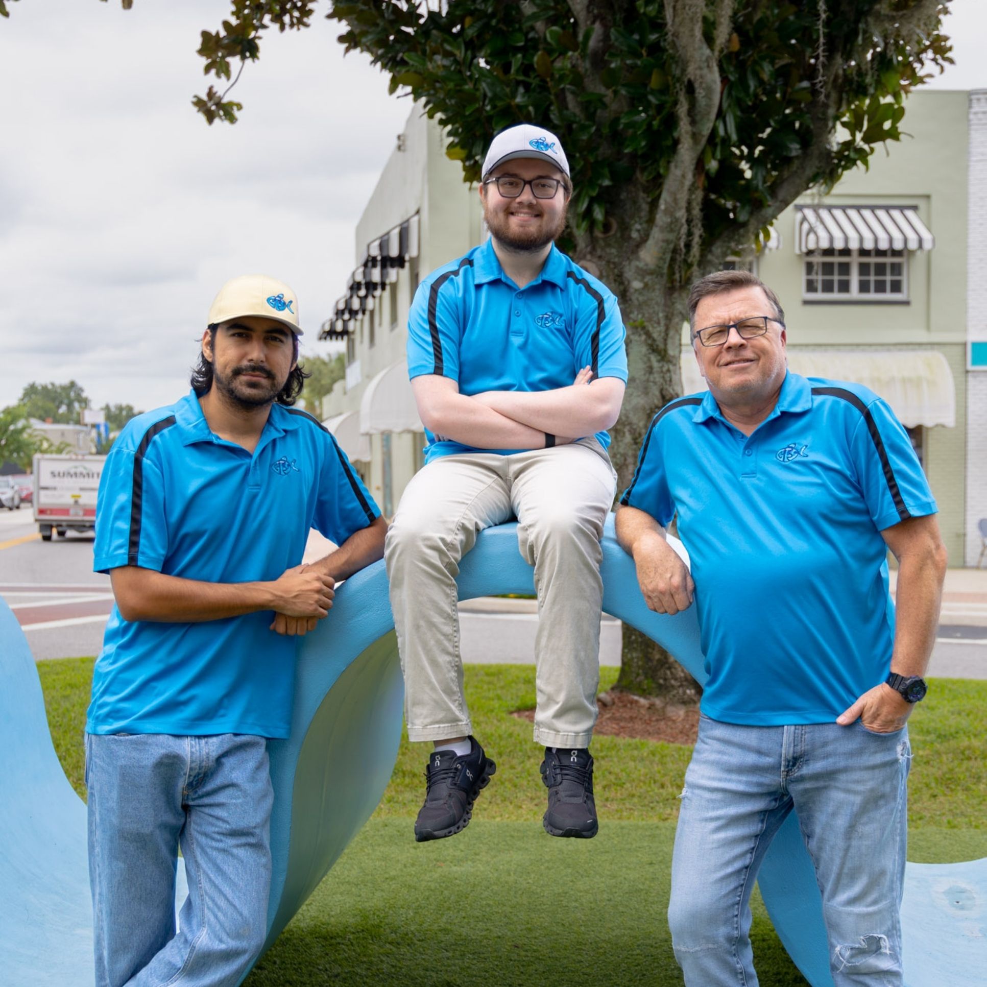 Two team members are shown from Get Fish Slapped. On the left is Jonathan Ace and the right is James McCoy. Jonathan Ace has dark hair and a dark, short beard. He is wearing a dark blue button down long-sleeve shirt. James McCoy has glasses, is clean shaven, and a short hair cut. He is wearing a light blue short-sleeve polo.